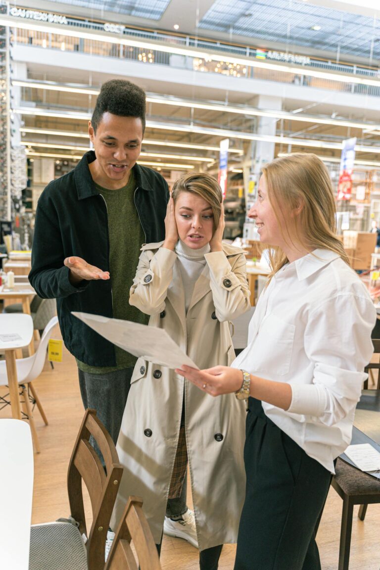 Man in Black Crew Neck Shirt Beside Woman in White Coat Holding White Paper